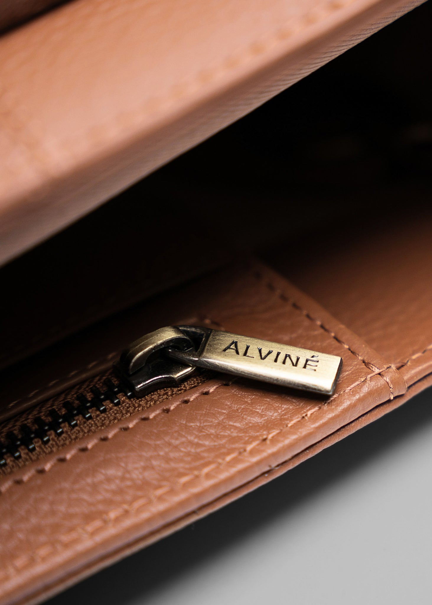 Close up af lynlås med ALVINÉ logo indeni en Cognac CC Arbejdstaske