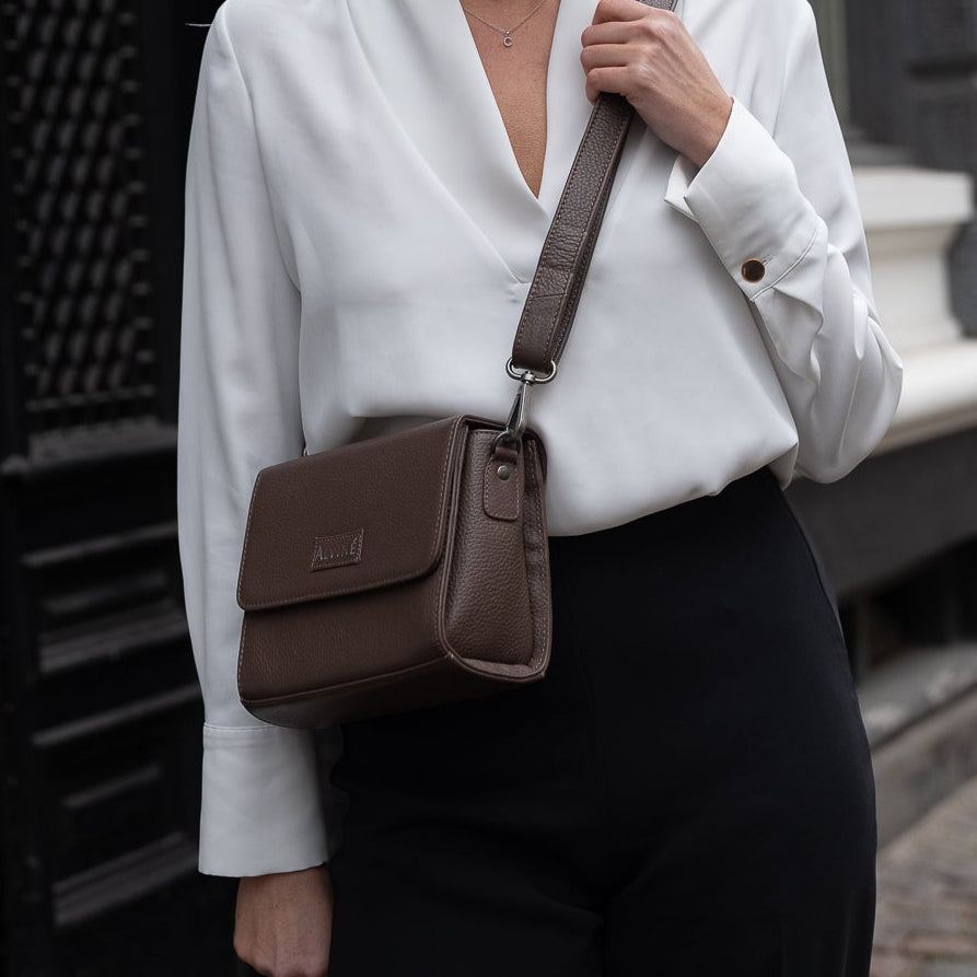 Close up af CC Pouch i Espresso læder som crossbody på kvinde i en hvid skjorte