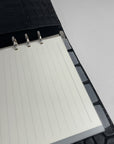 Close up af Horisontalle organiseringsfaner vist som inserts i en Sort Planner med krokodillestruktur