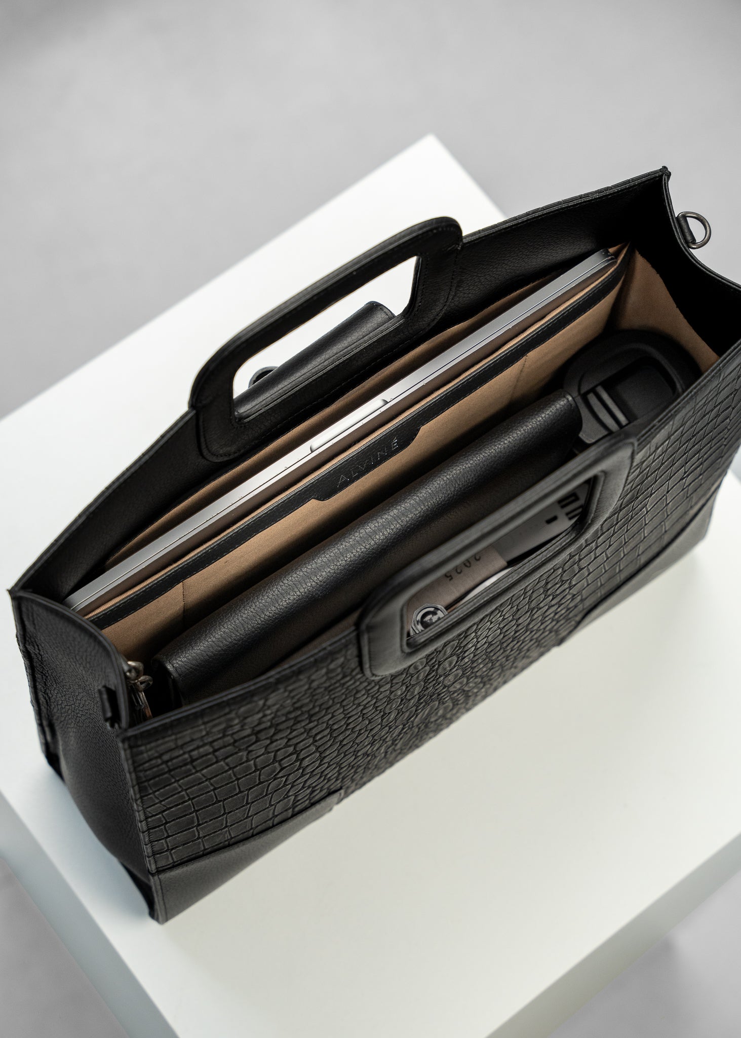 VGC Arbejdstaske i Sort læder med krokodillestruktur set oppefra og ned i tasken, med Essentials som f.eks. laptop, to-go kop og BC Organizer A5 i sort læder