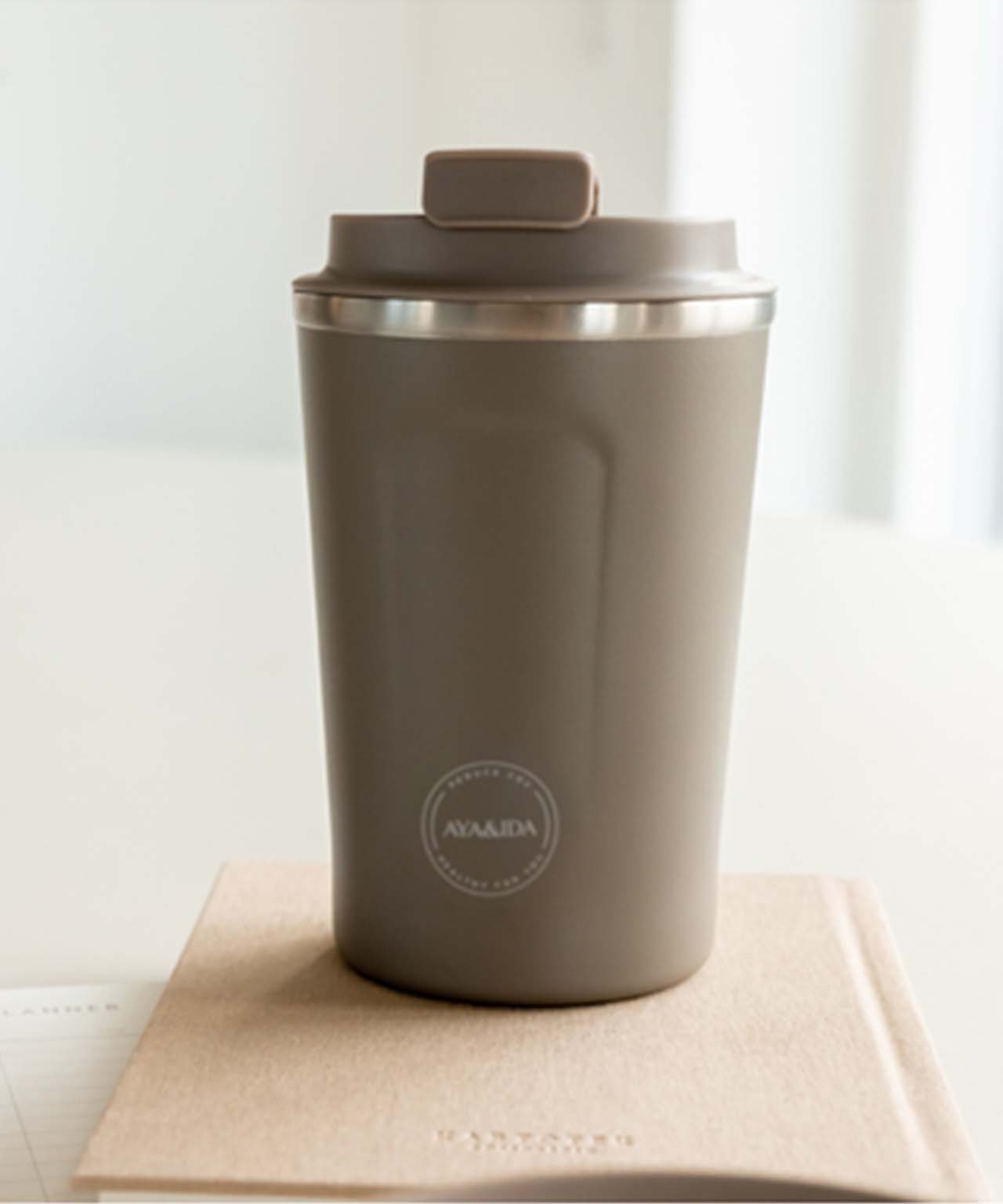 CUP2GO 380ml i Dusty Brown fra AYA&IDA på en bog