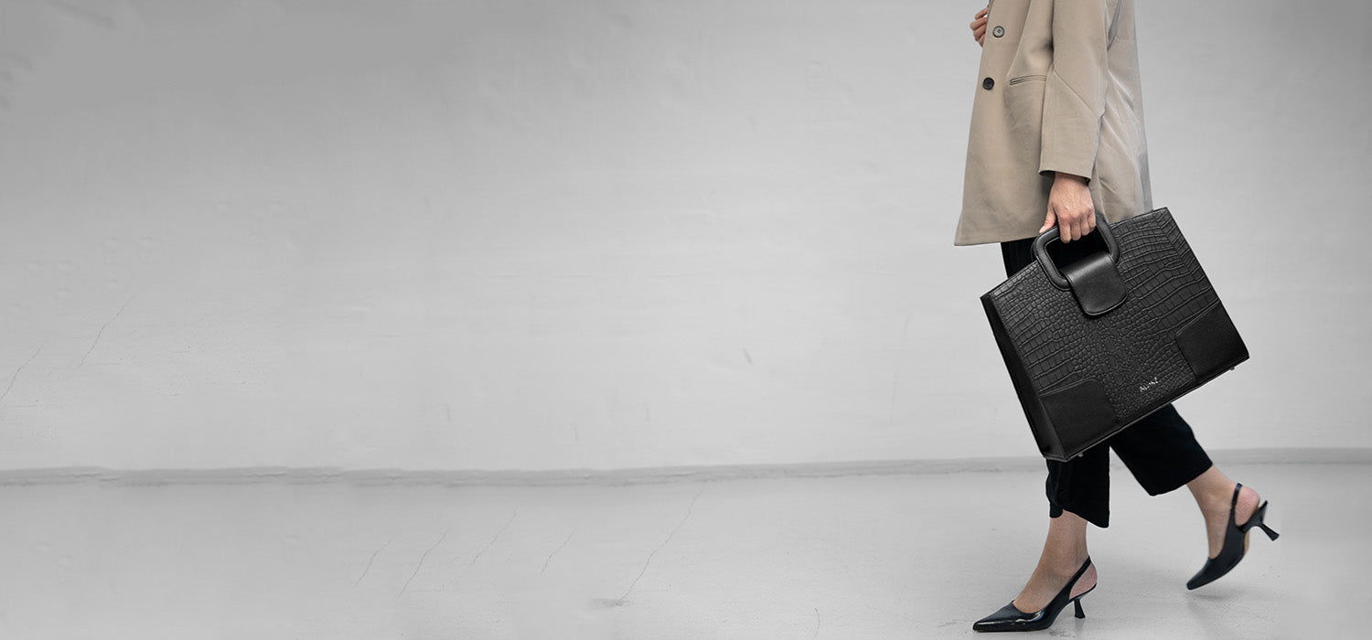 VGC Arbejdstaske i sort læder i hånden på kvinde