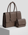 Arbejdstaske og Clutch i espresso læder fra The Classic Collection på pedestal