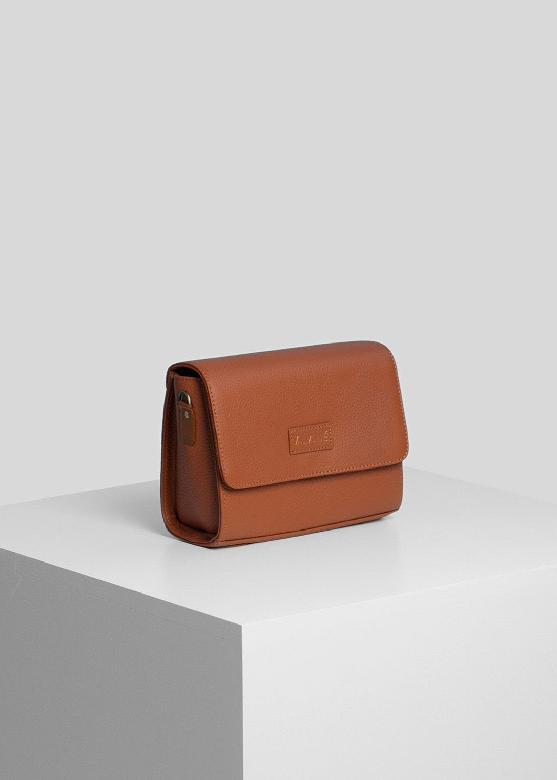 Pouch i cognac farve fra The Classic Collection på pedistal