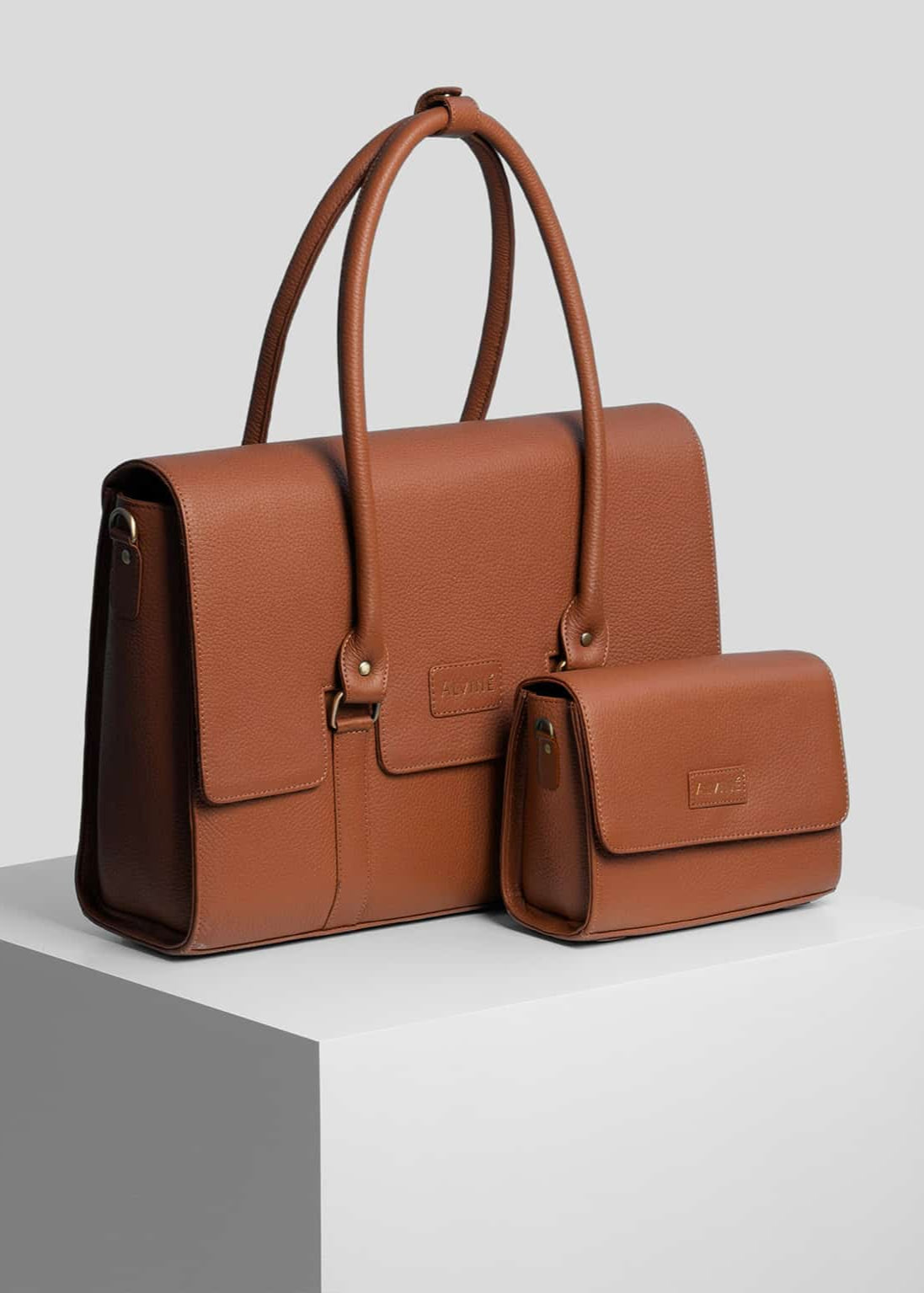 Arbejdstaske og Pouch i cognac farve fra The Classic Collection på pedistal